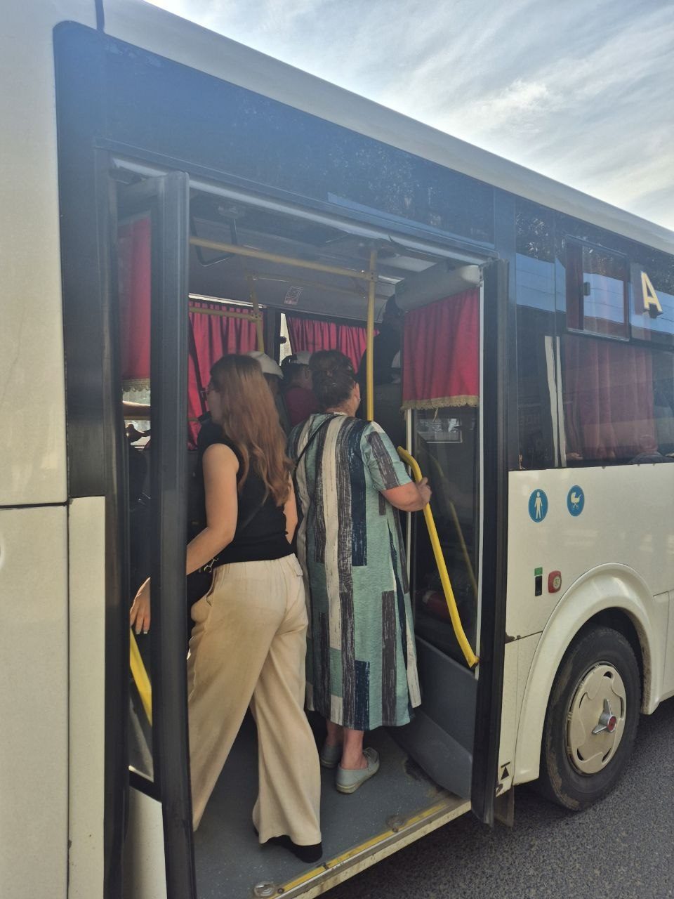 Passengers boarding an overcrowded bus